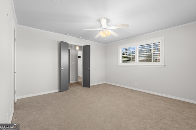 unfurnished bedroom featuring crown molding, baseboards, and light colored carpet