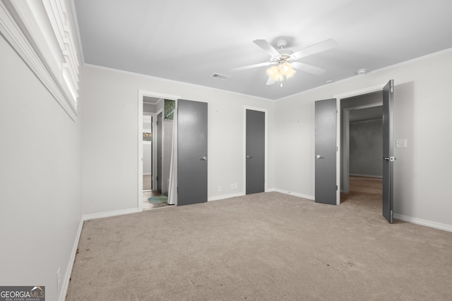 unfurnished bedroom with light carpet, ornamental molding, visible vents, and baseboards