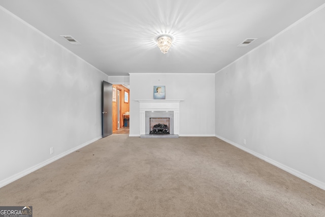 unfurnished living room with carpet floors, visible vents, a fireplace with raised hearth, and ornamental molding