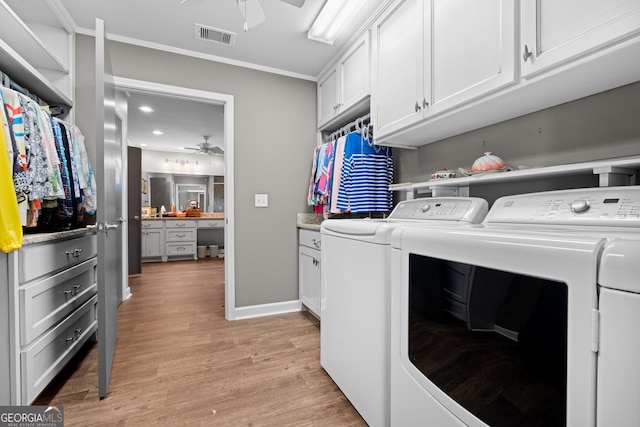 washroom featuring crown molding, visible vents, light wood-style flooring, a ceiling fan, and washing machine and dryer