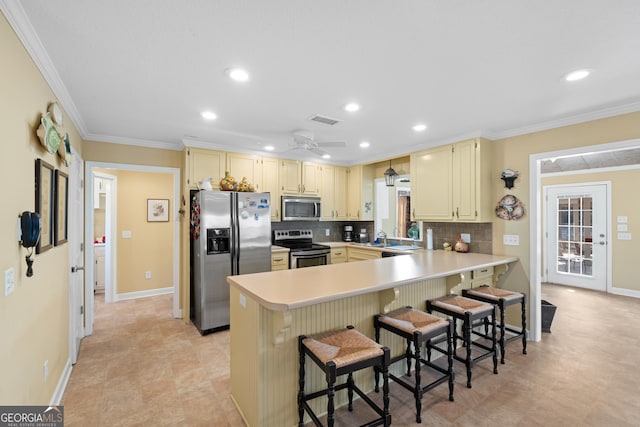 kitchen with visible vents, appliances with stainless steel finishes, a breakfast bar area, a peninsula, and light countertops