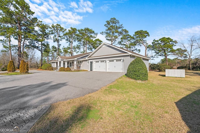 view of front of property featuring driveway, a garage, and a front yard