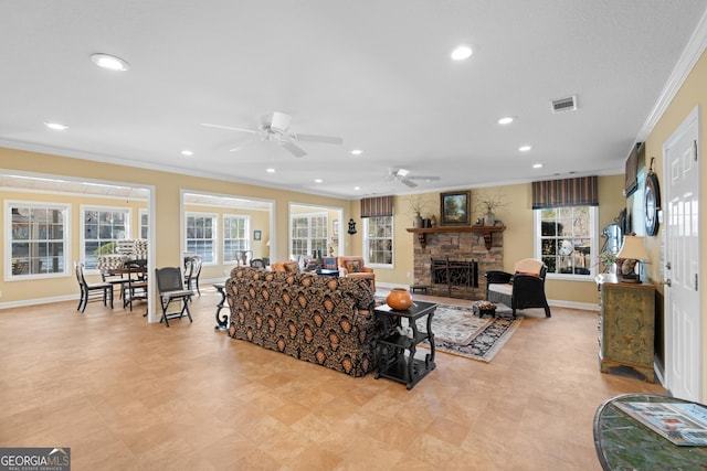 living room featuring a healthy amount of sunlight, a fireplace, visible vents, and ornamental molding