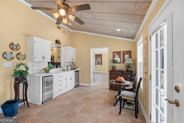 kitchen featuring white cabinets, appliances with stainless steel finishes, light countertops, and ornamental molding