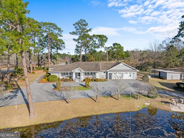 view of front of home with a garage, a water view, and driveway