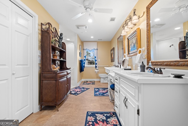 bathroom featuring visible vents, toilet, ceiling fan, vanity, and a closet