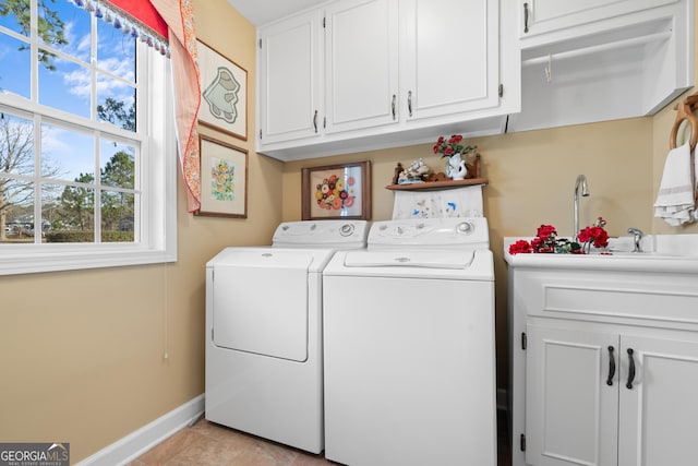 laundry area featuring baseboards, cabinet space, washing machine and clothes dryer, and light tile patterned floors