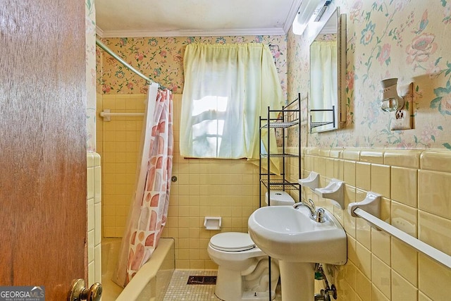 bathroom with ornamental molding, wainscoting, shower / bathtub combination with curtain, and wallpapered walls