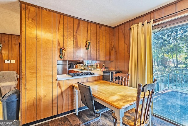 kitchen featuring stainless steel appliances, wood walls, light countertops, and brown cabinetry