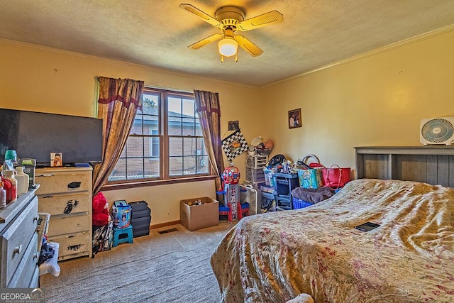 carpeted bedroom with visible vents, ornamental molding, ceiling fan, a textured ceiling, and baseboards