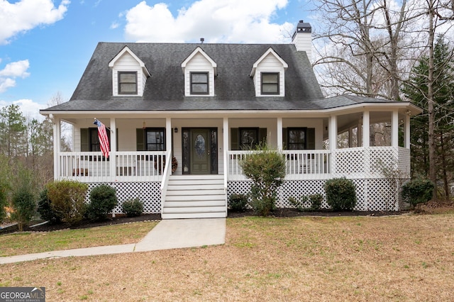 view of front of house featuring covered porch, a shingled roof, and a front yard