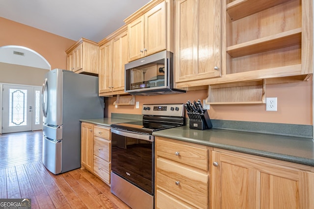 kitchen featuring appliances with stainless steel finishes, light brown cabinetry, open shelves, and light wood-style flooring