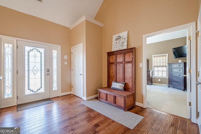 entryway featuring hardwood / wood-style floors, baseboards, and high vaulted ceiling