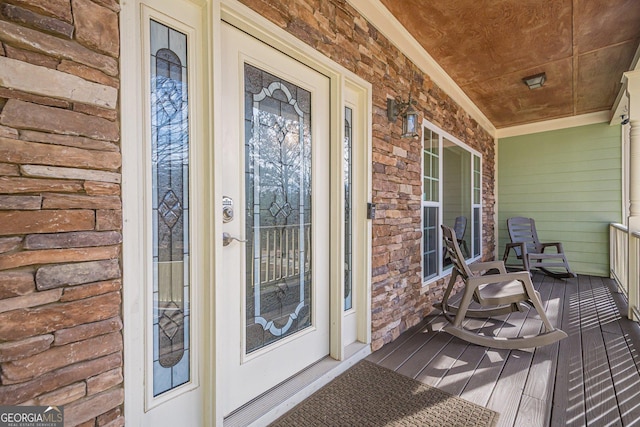 property entrance featuring covered porch and stone siding