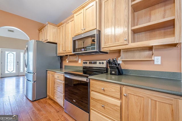 kitchen featuring light brown cabinetry, stainless steel appliances, light wood-style floors, and open shelves