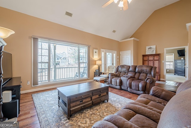 living room with ceiling fan, wood finished floors, high vaulted ceiling, and baseboards