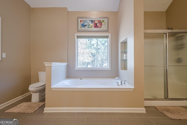 bathroom with toilet, a bath, baseboards, and a stall shower