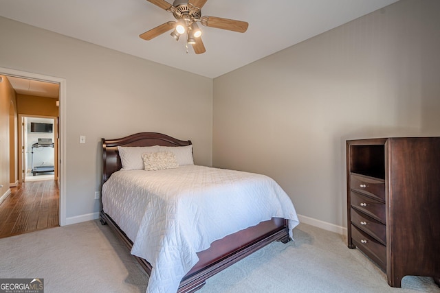 carpeted bedroom featuring ceiling fan, attic access, and baseboards