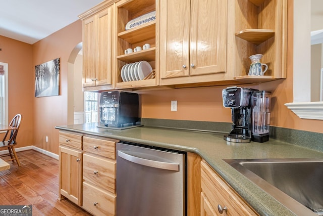 kitchen featuring open shelves, stainless steel dishwasher, light brown cabinetry, and arched walkways
