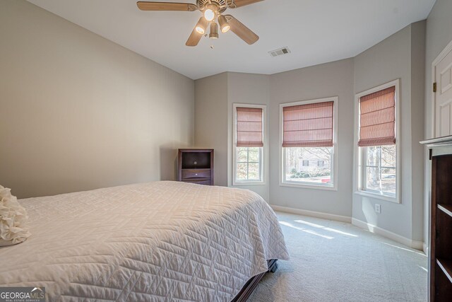 carpeted bedroom featuring baseboards, visible vents, and ceiling fan