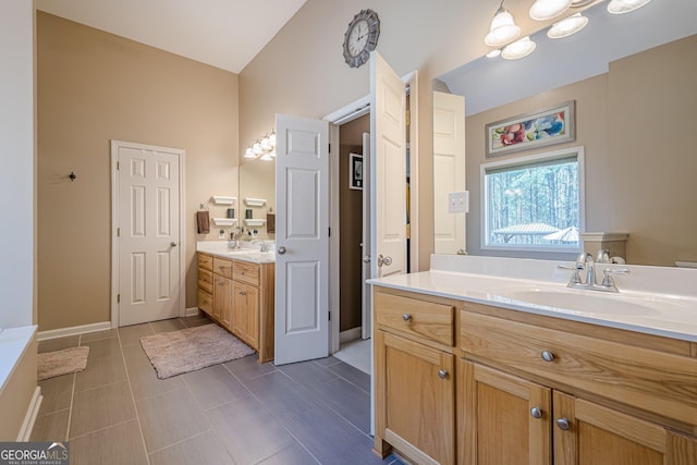 full bathroom featuring two vanities and baseboards