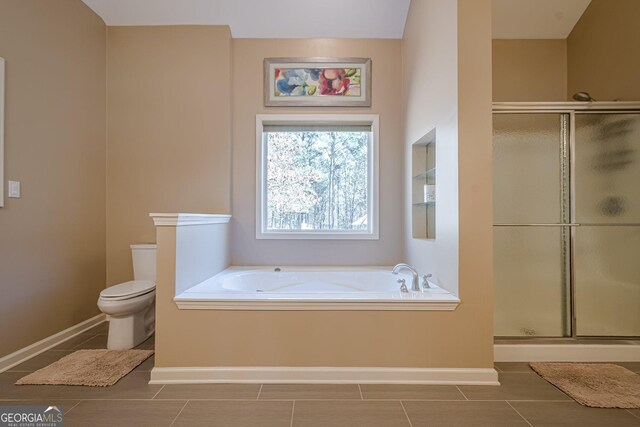 bathroom with a stall shower, a garden tub, toilet, and tile patterned flooring