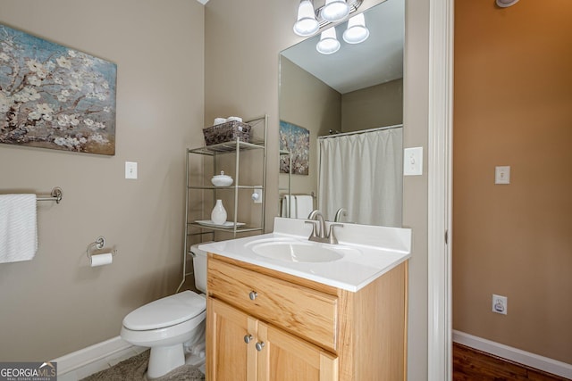 bathroom featuring baseboards, vanity, toilet, and curtained shower