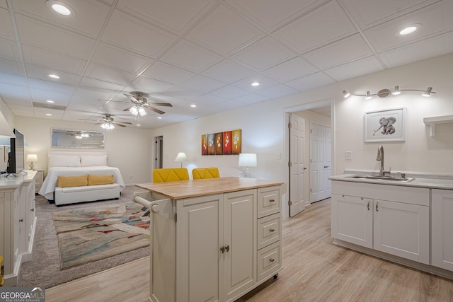 kitchen with a sink, light countertops, light wood finished floors, recessed lighting, and ceiling fan