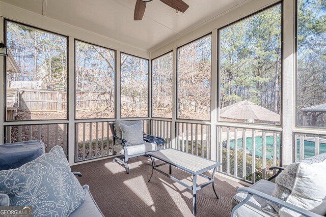 sunroom / solarium featuring a healthy amount of sunlight and a ceiling fan