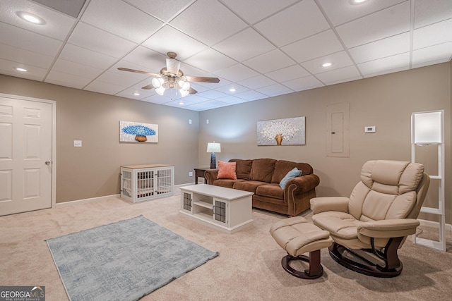 living room with light colored carpet, a ceiling fan, electric panel, a drop ceiling, and recessed lighting