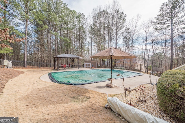 view of swimming pool featuring a gazebo, a patio area, a fenced in pool, and fence