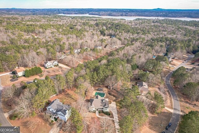 aerial view featuring a forest view and a water view