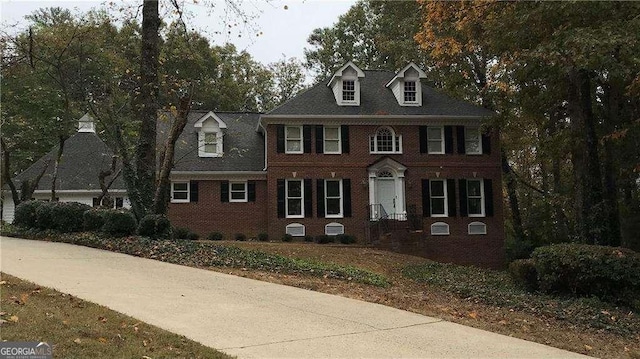 colonial inspired home featuring brick siding