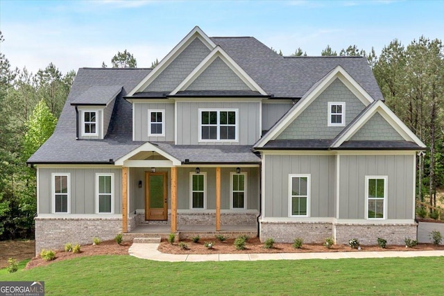 craftsman inspired home featuring board and batten siding, a porch, a front lawn, and roof with shingles