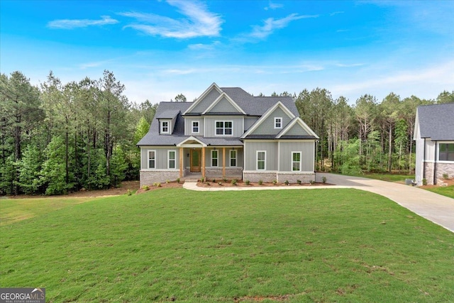 craftsman-style house featuring a porch, a front yard, and concrete driveway