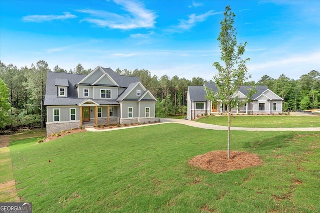 craftsman house with a porch, a front yard, and stone siding