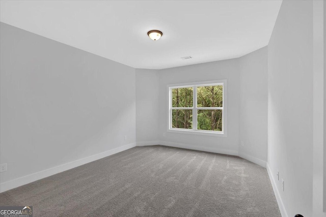 carpeted spare room featuring baseboards