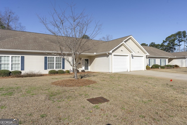 ranch-style house with concrete driveway, a shingled roof, an attached garage, and a front yard