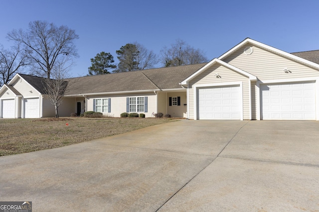 single story home with concrete driveway and an attached garage