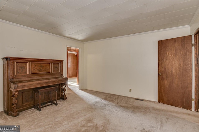 interior space with ornamental molding, visible vents, and light colored carpet