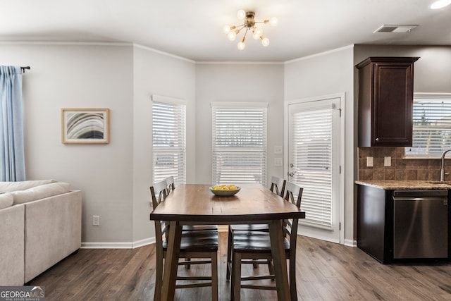 dining room with baseboards, visible vents, dark wood finished floors, and ornamental molding