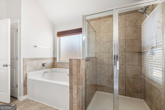 bathroom with a garden tub, vaulted ceiling, tile patterned flooring, and a shower stall