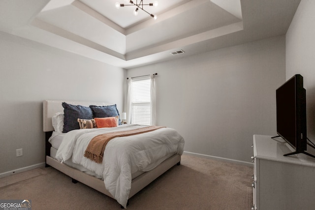 bedroom with a tray ceiling, visible vents, light carpet, a chandelier, and baseboards