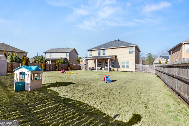 back of house featuring a lawn, a playground, and a fenced backyard