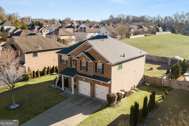 view of front facade with fence, driveway, and a front lawn