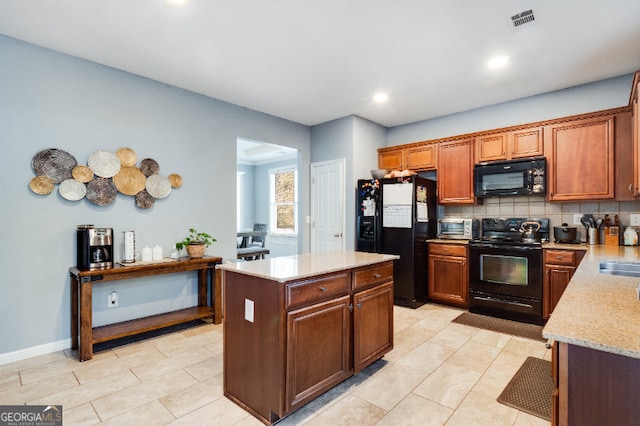 kitchen with a center island, visible vents, brown cabinets, black appliances, and tasteful backsplash