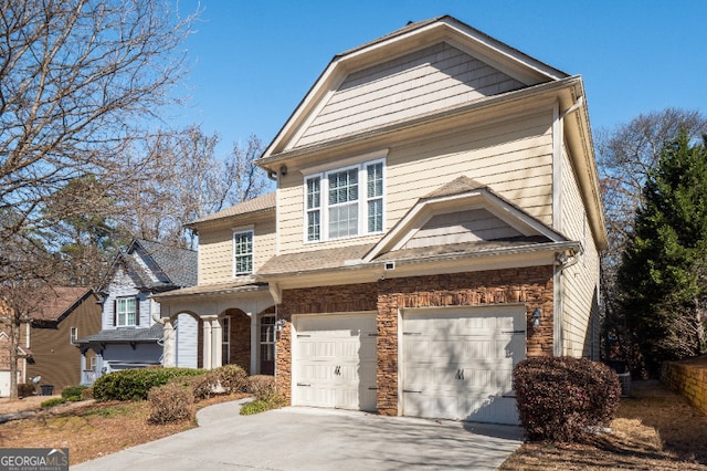 view of front of property with a garage, stone siding, and driveway