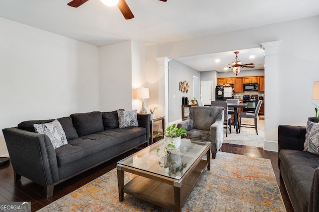 living room with ceiling fan, dark wood-type flooring, baseboards, and ornate columns