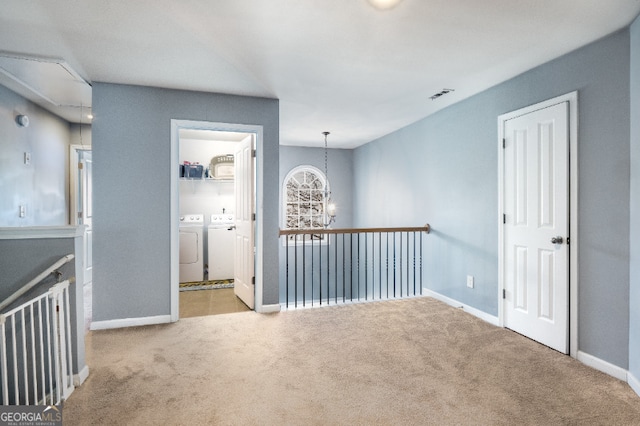 spare room with attic access, visible vents, separate washer and dryer, and light colored carpet