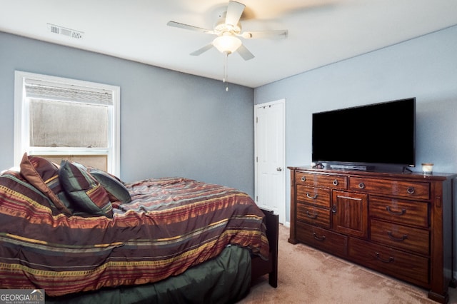 bedroom featuring a ceiling fan, light colored carpet, and visible vents